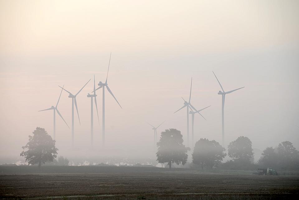 Sept éoliennes dans la brume. 