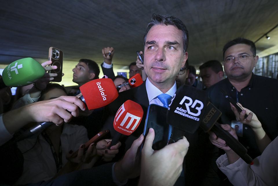 Flávio Bolsonaro parle devant des micros de journalistes.