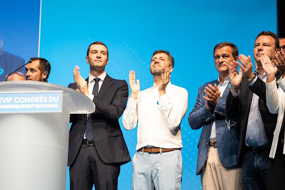 Franck Allisio, candidat RN/FN à Marseille (en blanc), avec Jordan Bardella et Louis Alliot, maire de Perpignan, applaudissant sur une tribune