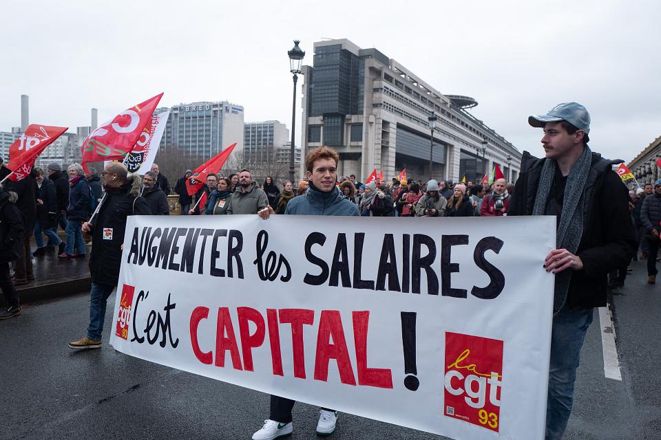 Trois manifestants portent une banderole "Augmenter les salaires c'est capital", siglées CGT 93. Ils sont dans une manifestation.