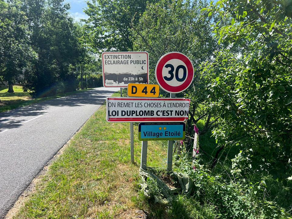 Des panneaux "On remet les choses à l'endroit", "loi Duplomb c'est non", à l'entrée d'une commune
