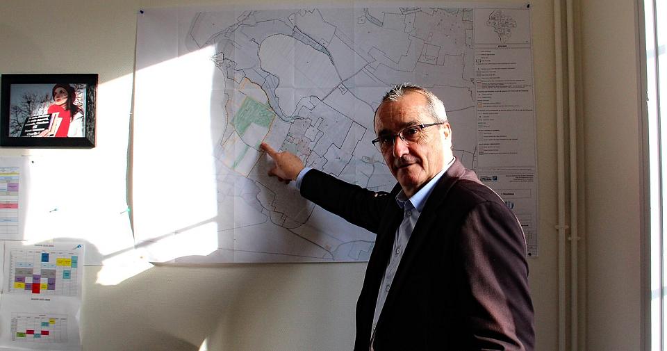 Un homme d'une soixantaine d'années pointe une carte avec son doigt