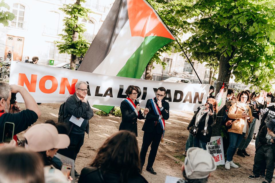 Une banderole "Non à la loi Yadan" déployée devant quelques dizaines de personnes