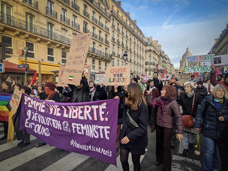 Des manifestantes tiennent une banderole "Femme, vie, liberté". 