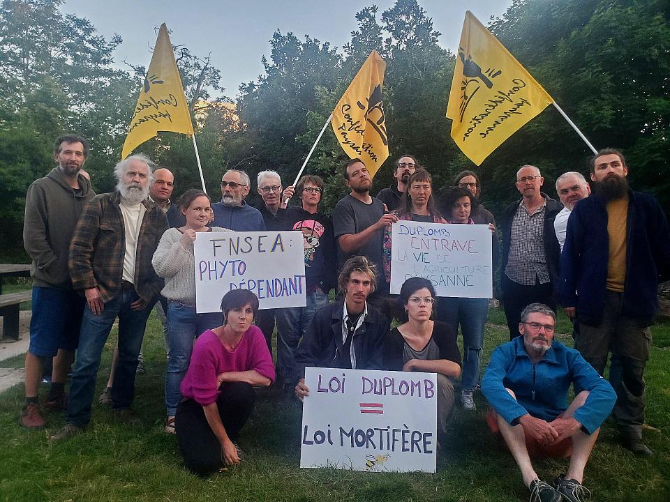 des femmes et hommes tiennent des panneaux "loi duplomb-loi mortifère", 'fnsea phytodépendant" avec des drapeaux de la Confédération paysanne