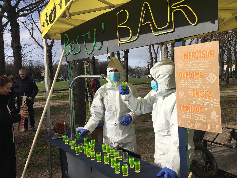 un "pesti'bar" avec deux personnes en combinaison blanche et masquées
