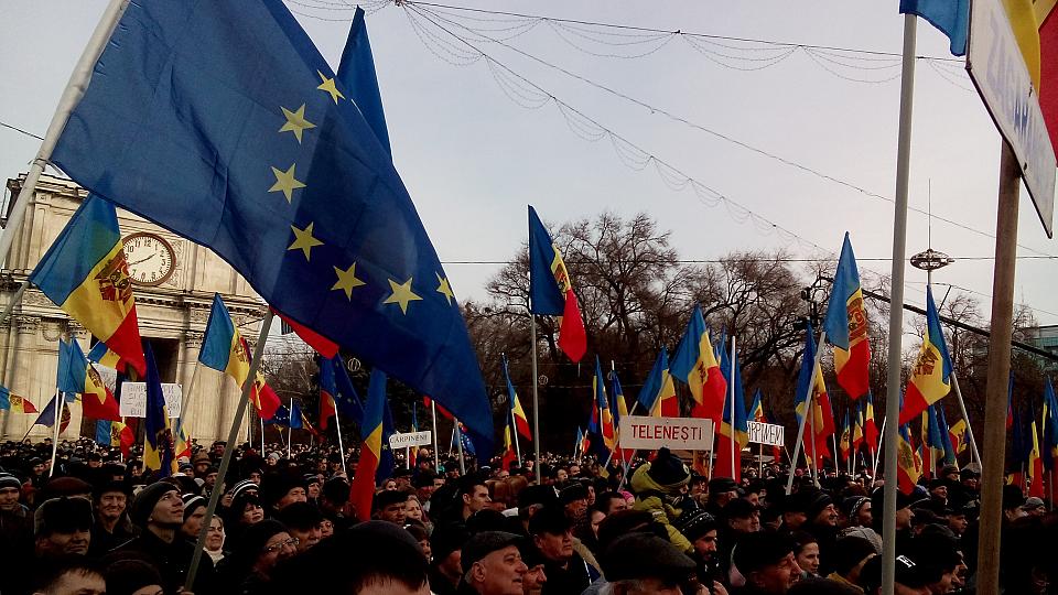 Une foule brandissant des drapeaux de la Moldavie et de l'Union européenne.. 