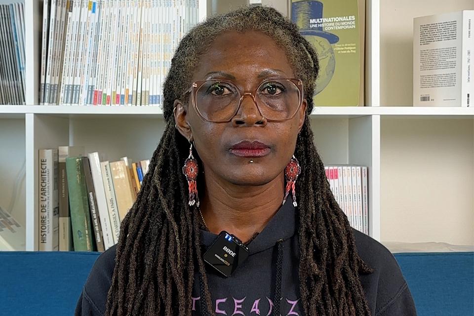 portrait de Fatou Dieng, devant une bibliothèque