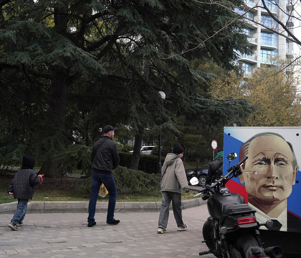 Une peinture représentant Vladimir Poutine sur fonds rouge, blanc et bleu, dans une rue.