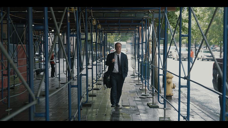 un homme en costume cravate marche dans une rue aux Etats Unis