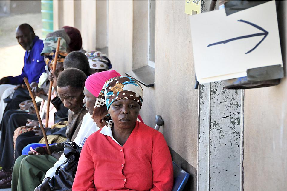 Des personnes attendent sur un banc.