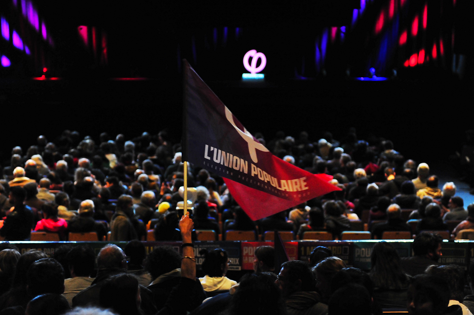 Au meeting de Jean-Luc Mélenchon, à Besançon, le 5 avril 2022. Un drapeau de l'Union populaire est brandi dans la foule venue pour le meeting du leader de la France Insoumise.