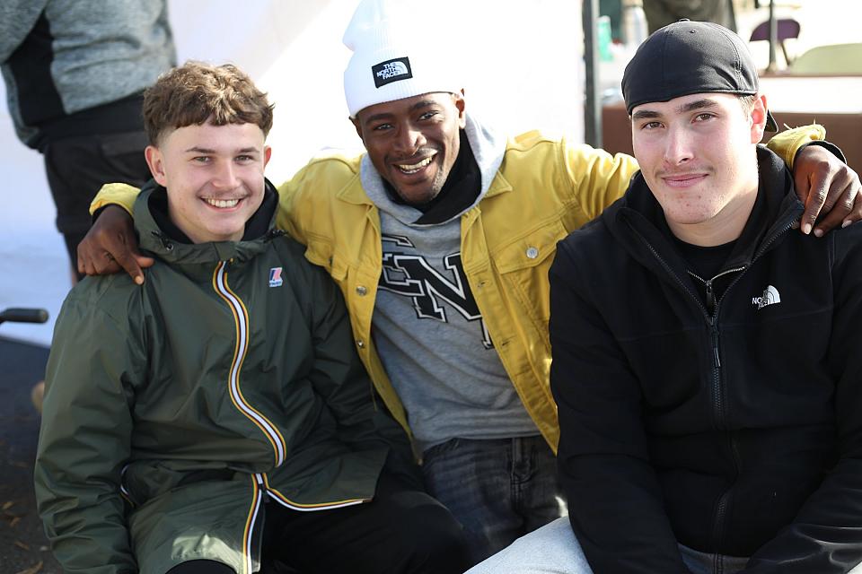 Trois jeunes bras dessus bras dessous. 