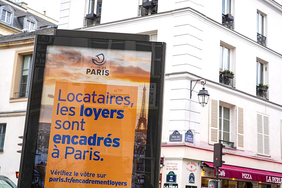 Une affiche de la Ville de Paris informe les locataires que les loyers de leur logement en location sont encadrés a Paris avec l'adresse du site internet pour vérifier l'encadrement des loyers des appartements sur un panneau publicitaire dans une rue du 3ème arrondissement de Paris en Ile de France le 24 décembre 2025.
