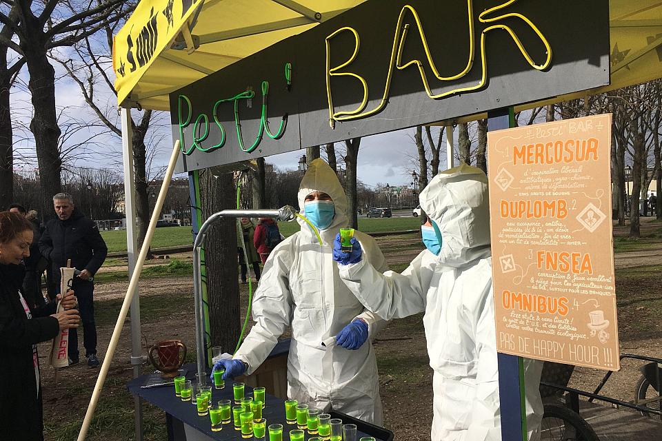 un "pesti'bar" avec deux personnes en combinaison blanche et masquées