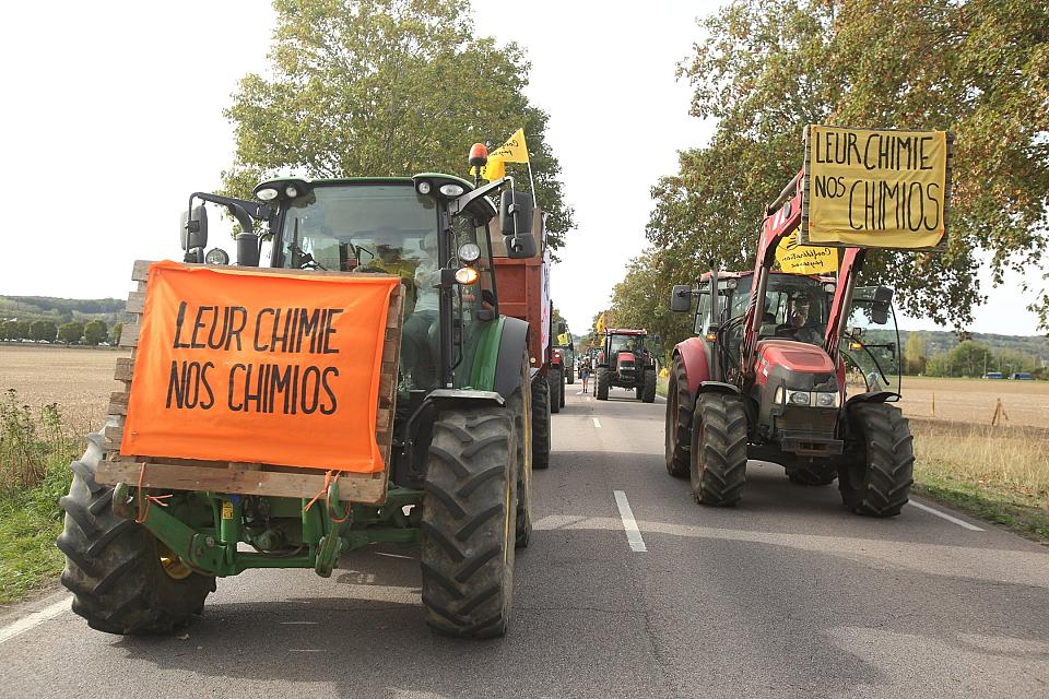 des tracteurs brandissent des banderoles "leur chimie, nos chimios" sur une route
