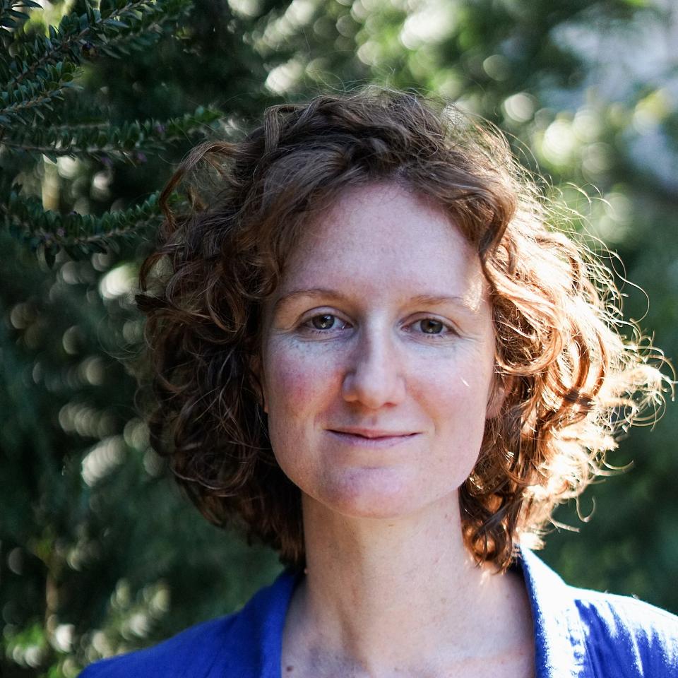Potrait d'Elise Boutié, souriante, devant des arbres