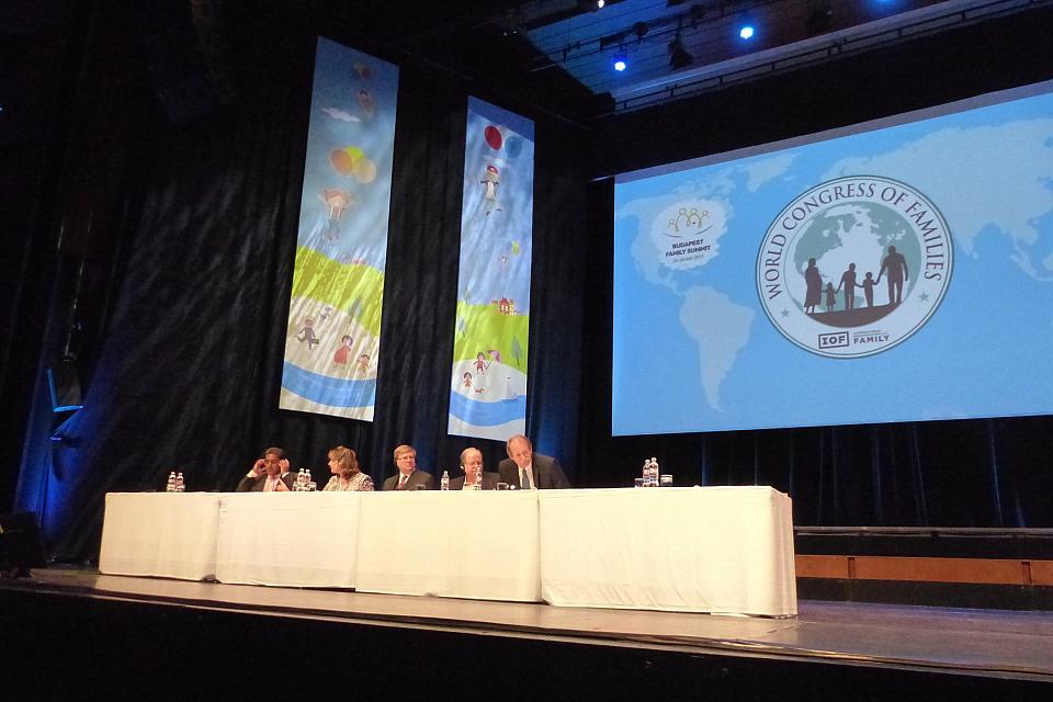 Une estrade acec des hommes et des femmes assez âgées sur une scène, on voit le logo du World Congress of Families en fond de scène.
