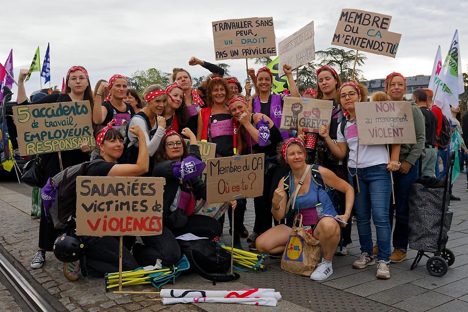 Un groupe de femmes devant des pancartes.