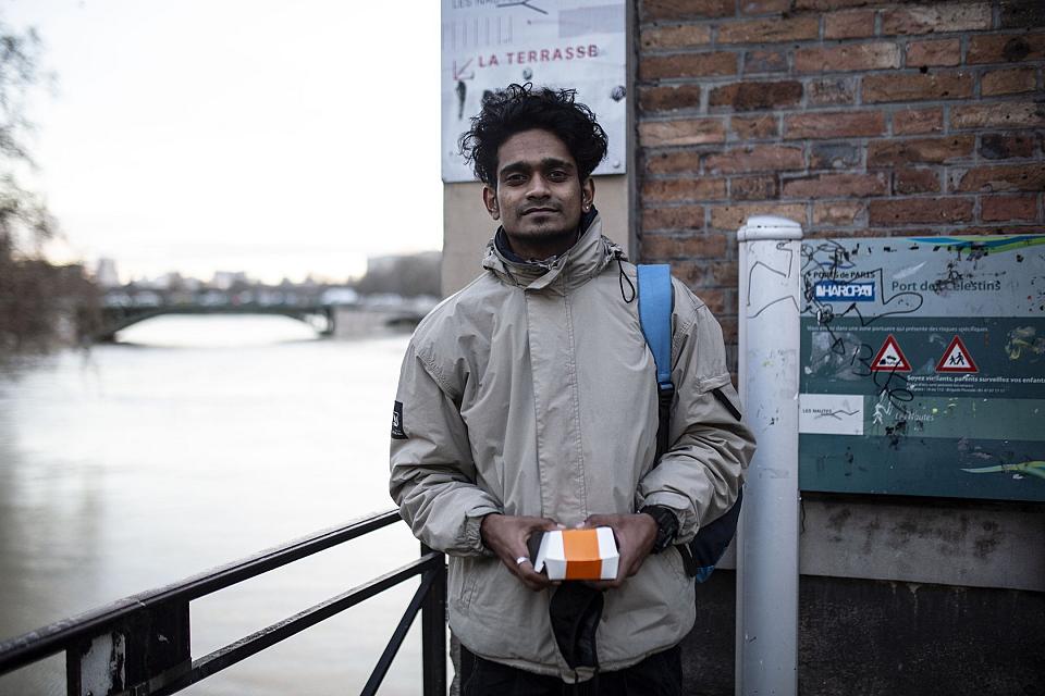 un jeune homme debout souriant près d'un canal