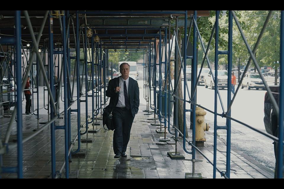 un homme en costume cravate marche dans une rue aux Etats Unis