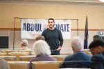 Abdul El-Sayed en jean et tshirt dans une salle, debout face à des peronnes assises, vues de dos.