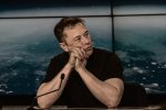 Elon Musk, les mains jointes, devant un micro