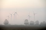 Sept éoliennes dans la brume. 