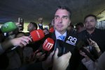 Flávio Bolsonaro parle devant des micros de journalistes.