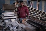 Un travailleur devant la machine faisant défiler la pâte