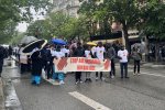 Des personnes marchent dans la rue avec une banderole 