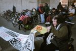 Un rassemblement de plusieurs personnes en fauteuil roulant, on distingue une banderole tenue par l'une de ces personnes. 