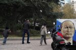 Une peinture représentant Vladimir Poutine sur fonds rouge, blanc et bleu, dans une rue.