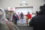 Un homme parle au milieu d'un rassemblement. Des personnes portent des drapeaux de France nature environnement.