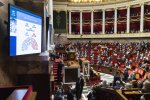 Vue sur un écran détaillant les votes face à l'hémicycle de l'Assemblée nationale. On distingue 299 pour en bleu, 226 contre en rouge.