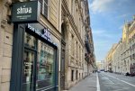 Photo d'une rue parisienne, avec en premier plan une enseigne Shiva.