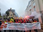 La tête du cortège d'une manifestation : des manifestants portent une banderole 