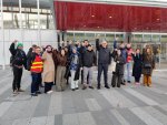 Une douzaine de personnes debout devant le bâtiment du tribunal judiciaire de Paris levant le poing. 