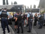 En rang, des gendarmes fouillent des lycéens, en arrière plan on aperçoit des bus.