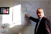 Un homme d'une soixantaine d'années pointe une carte avec son doigt