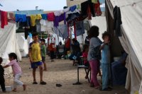 Des enfants parmi des allées de tentes