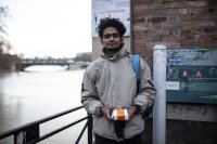 un jeune homme debout souriant près d'un canal