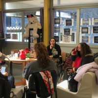 Une réunion dans un local. Une dizaine de personnes assises autour d'une table. 