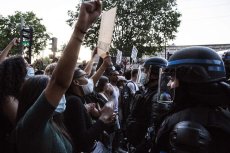 Des manifestantes et manifestants face à des policiers casqués.